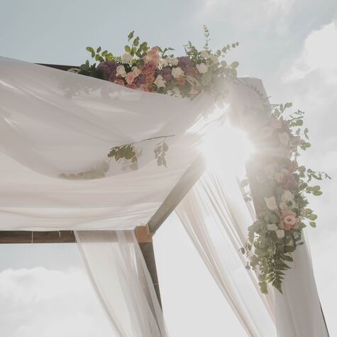 partial view of a chuppah with sun shining through 