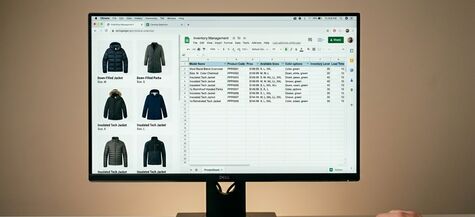 computer monitor with spreadsheet and photos of coats